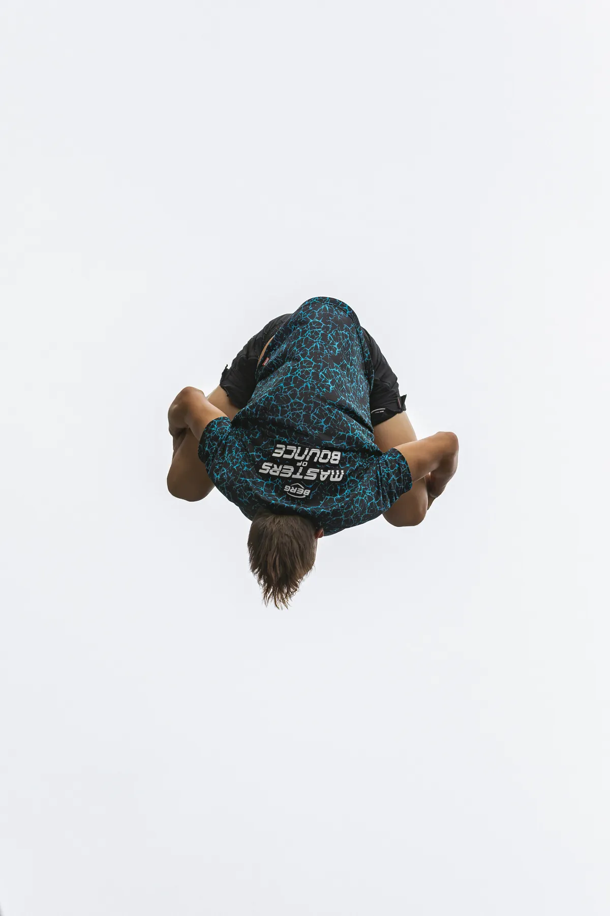 Gehockter Salto vor weißem Himmel