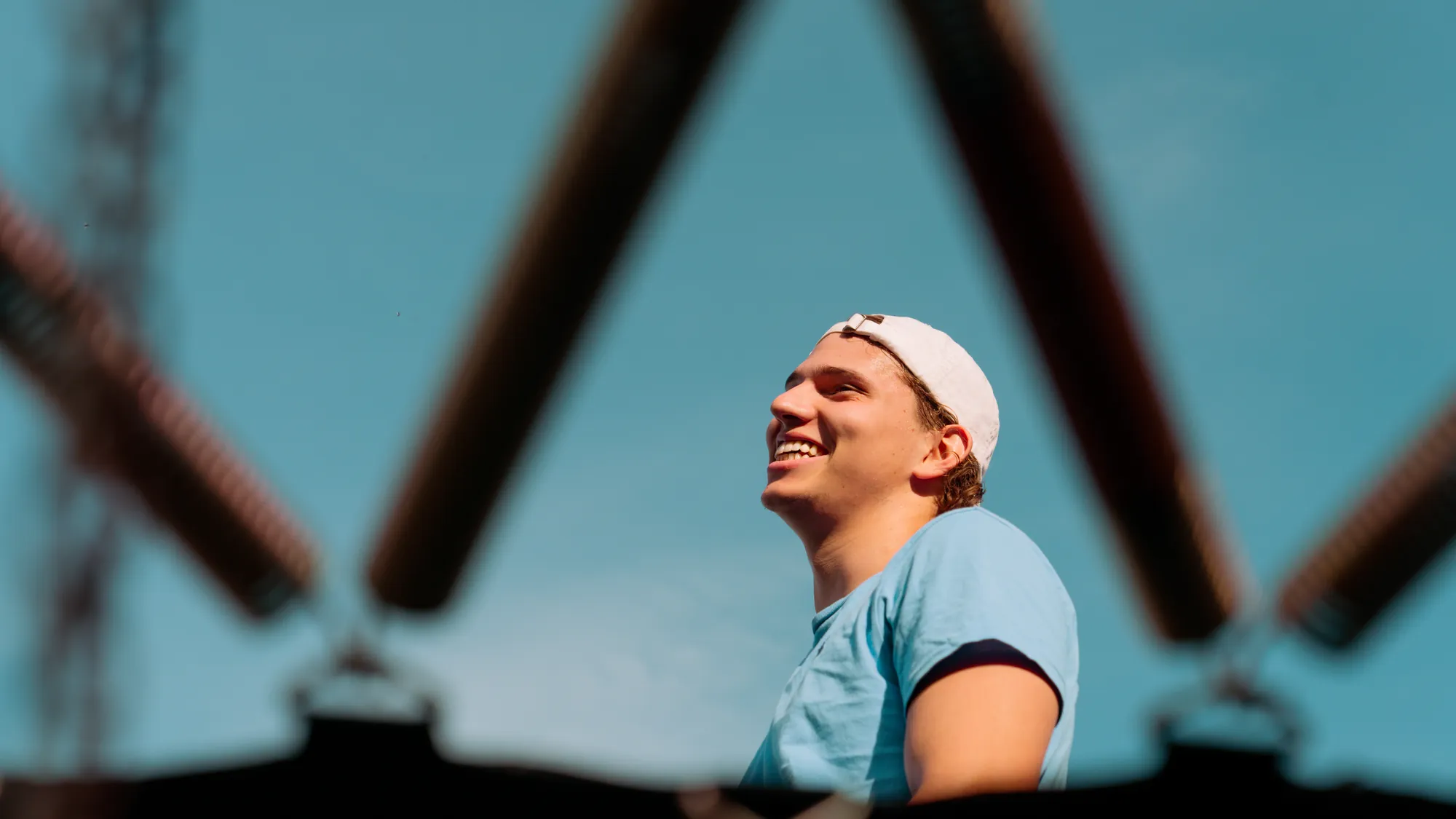 Noah lächelt unter einem Trampolin in den Himmel